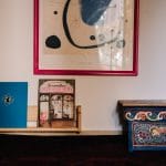 Children's bedroom with art on wall, low bookshelf and books with covers facing forward