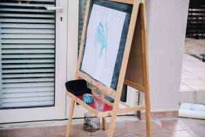 Painting with blue paint stuck onto child's easel on terrace