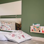 Children's playroom reading area with low bookshelf with book covers facing forward