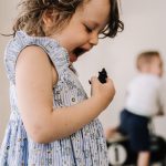 Preschooler laughing as she growls at animal figurine