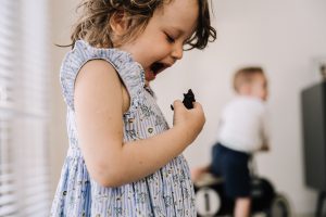 Preschooler laughing as she growls at animal figurine